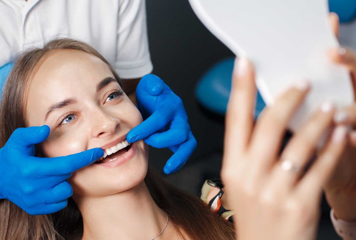 A dentist in gloves treating a patient in the chair at a Manya Dental clinic